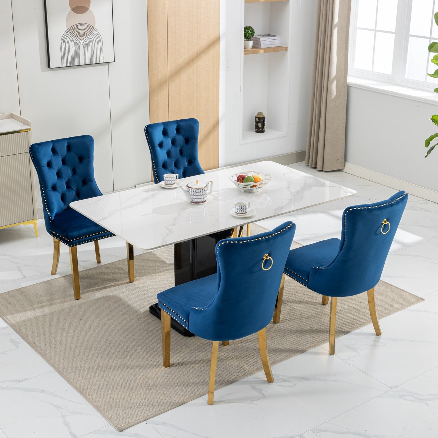 Luxurious blue velvet dining chairs with gold accents around a marbletop table