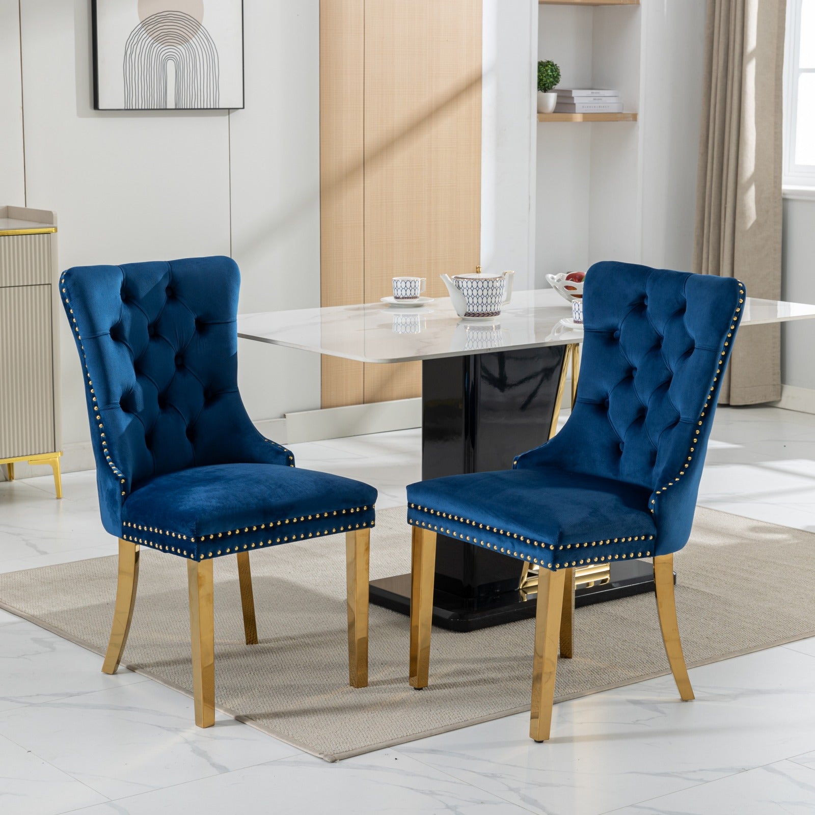 Deep blue velvet dining chair with gold nailhead trim and brass legs