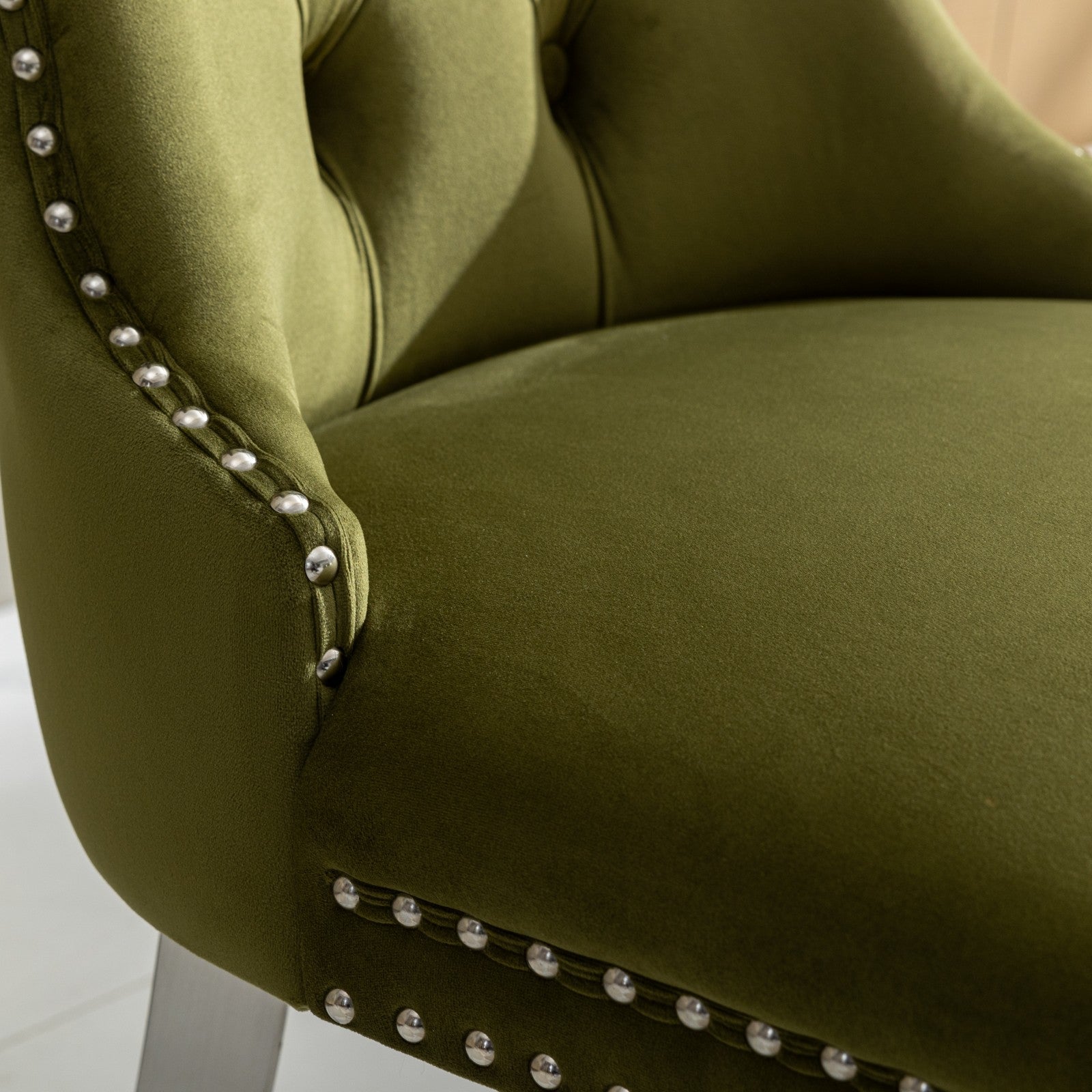 Green velvet armchair with silver nailhead trim detail