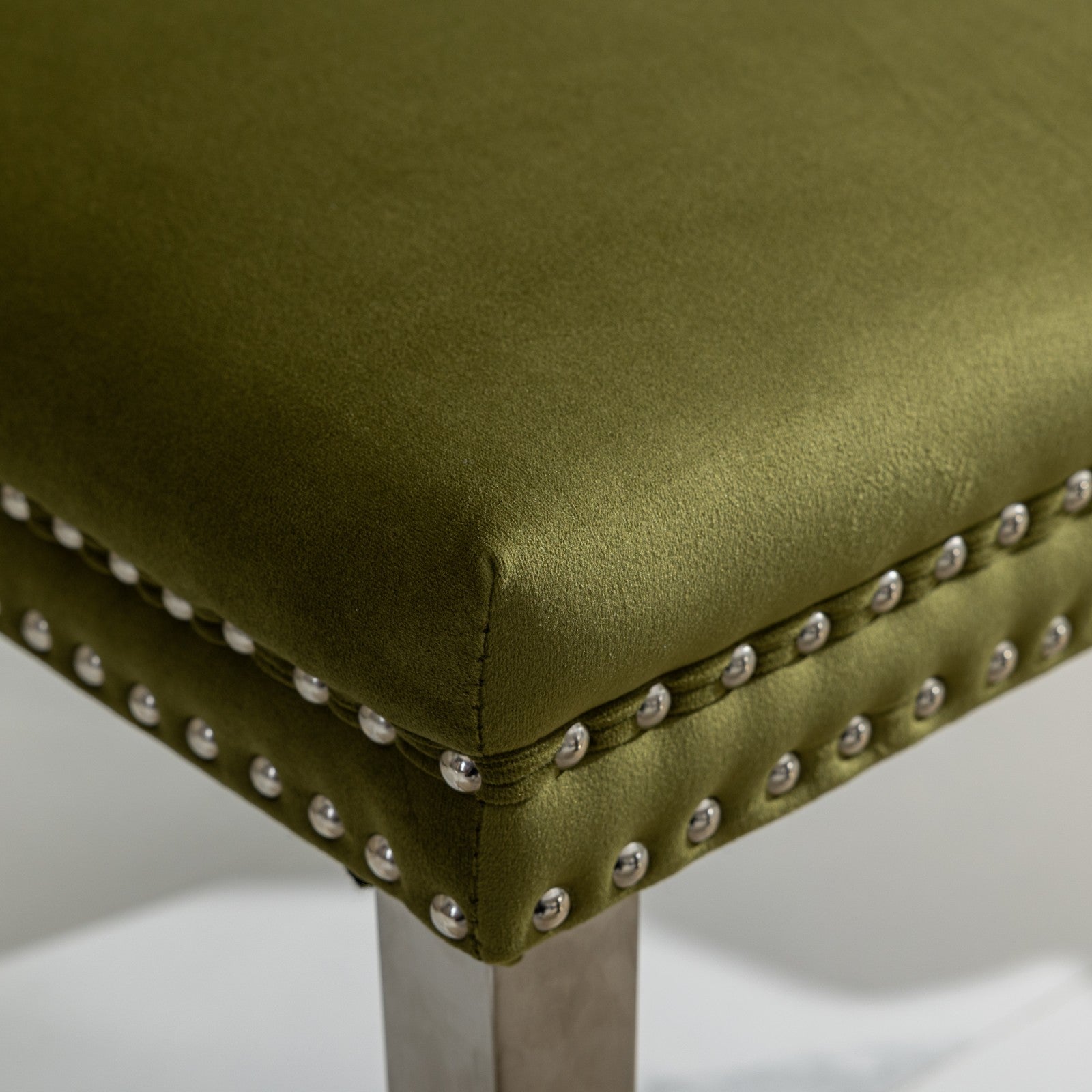 Emerald green velvet ottoman with silver nailhead trim detail