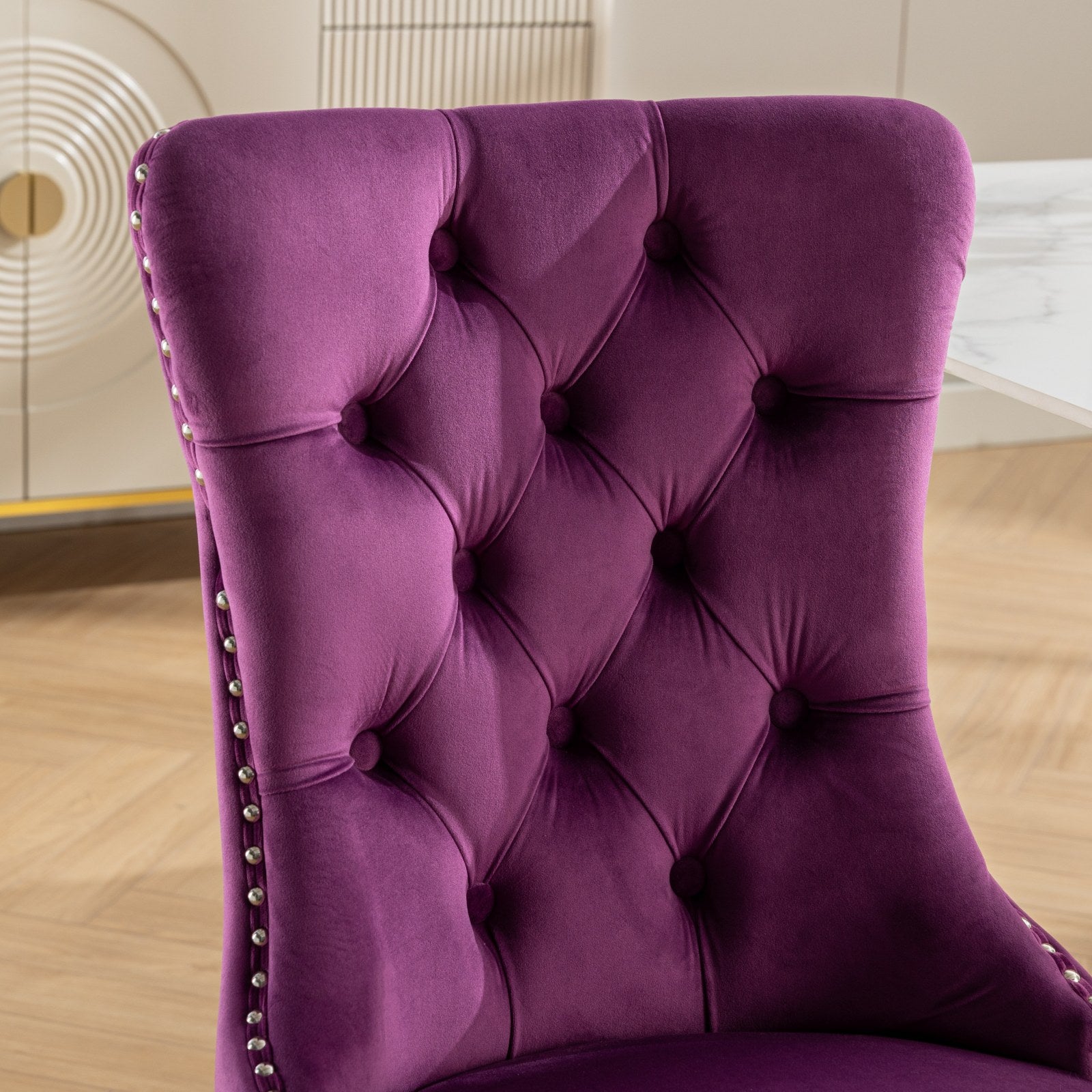 Plush purple velvet tufted dining chair with silver nailhead trim details