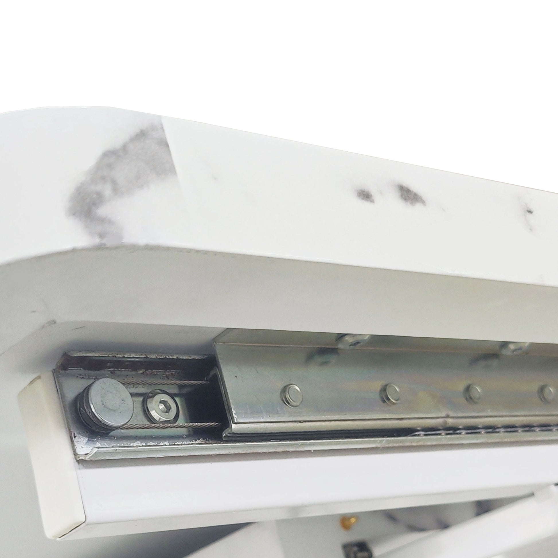 Closeup of white marble effect desktop edge showing internal drawer slider mechanism and stainless steel screws