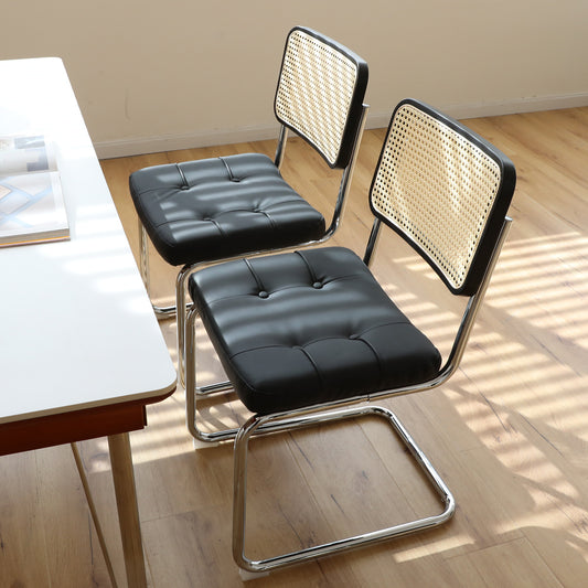 Black tufted leather dining chair with cane back and chrome frame