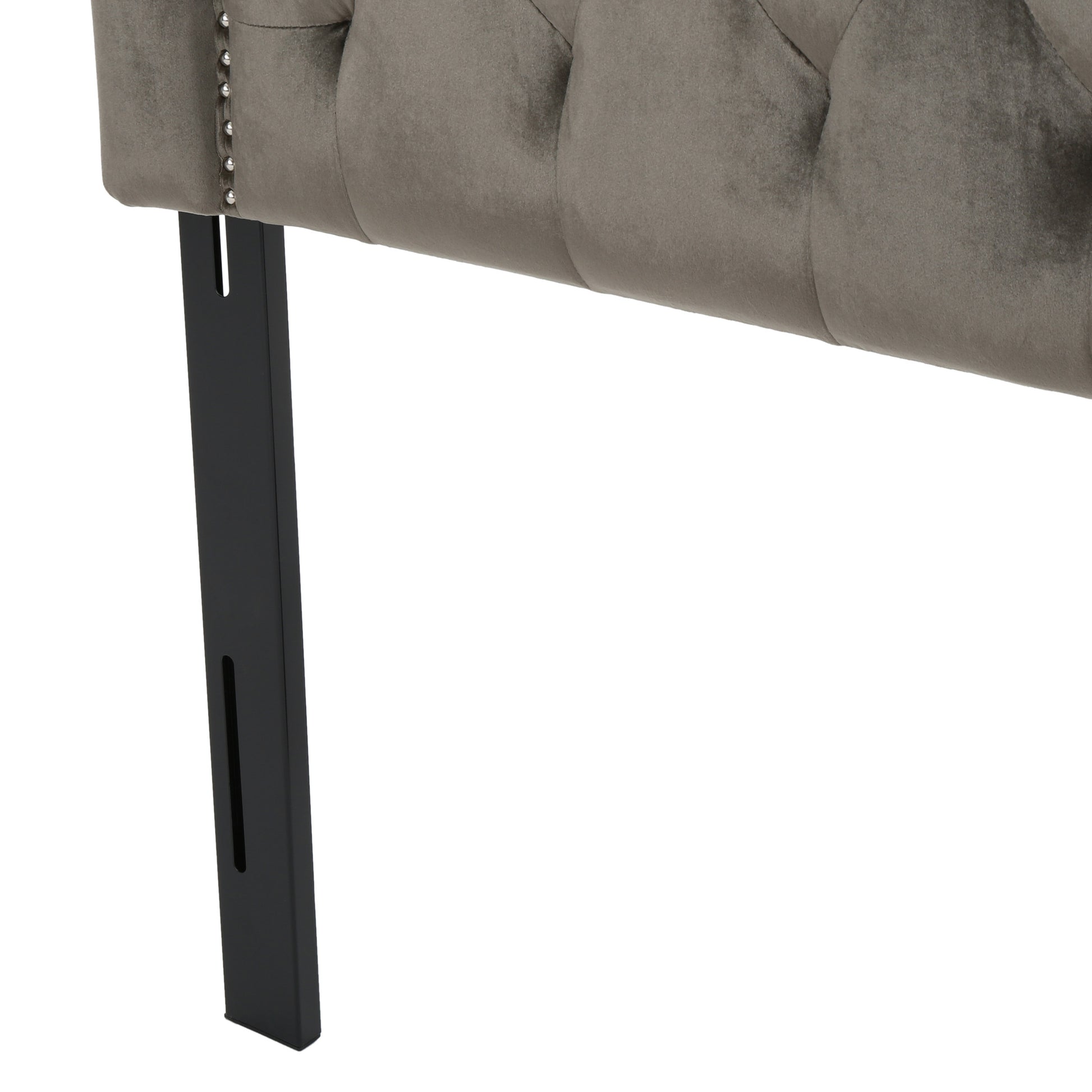 Grey velvet headboard detail with tufted design and silver nailhead trim