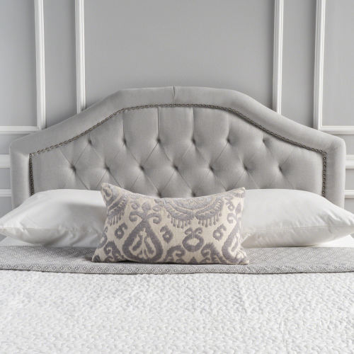Tufted grey fabric headboard with nailhead trim detail