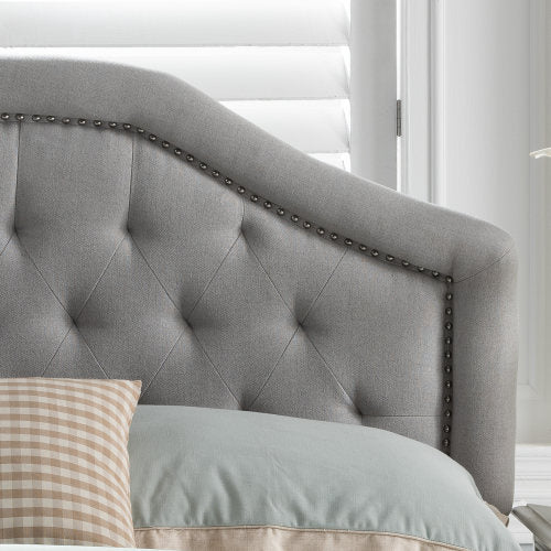 Gray upholstered headboard with diamond tufting and nailhead trim
