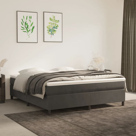 Dark grey upholstered bed frame with white bedding and a grey throw blanket