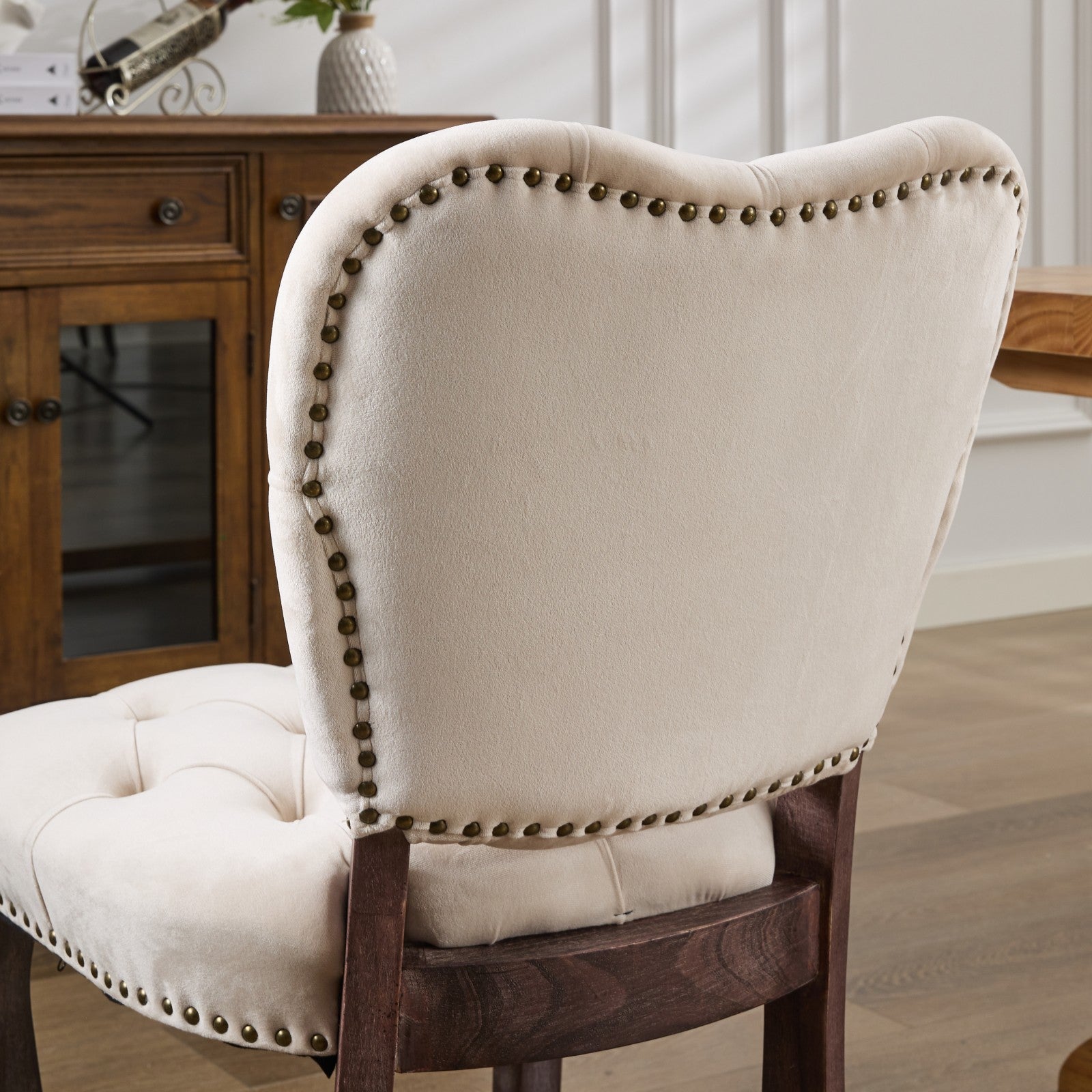 Cream tufted velvet dining chair with antique brass nailhead trim