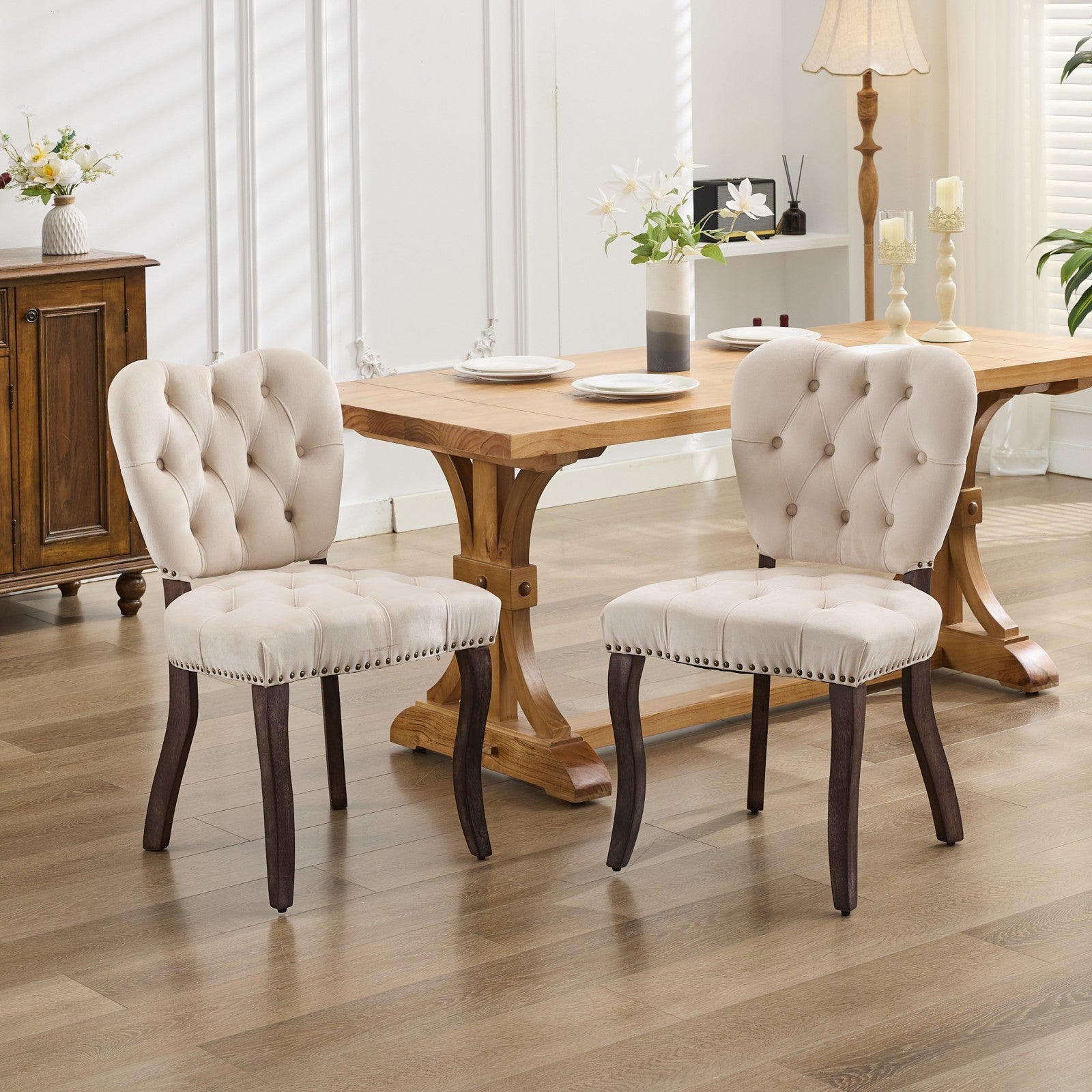 Cream velvet dining chair with button tufting and dark wood legs