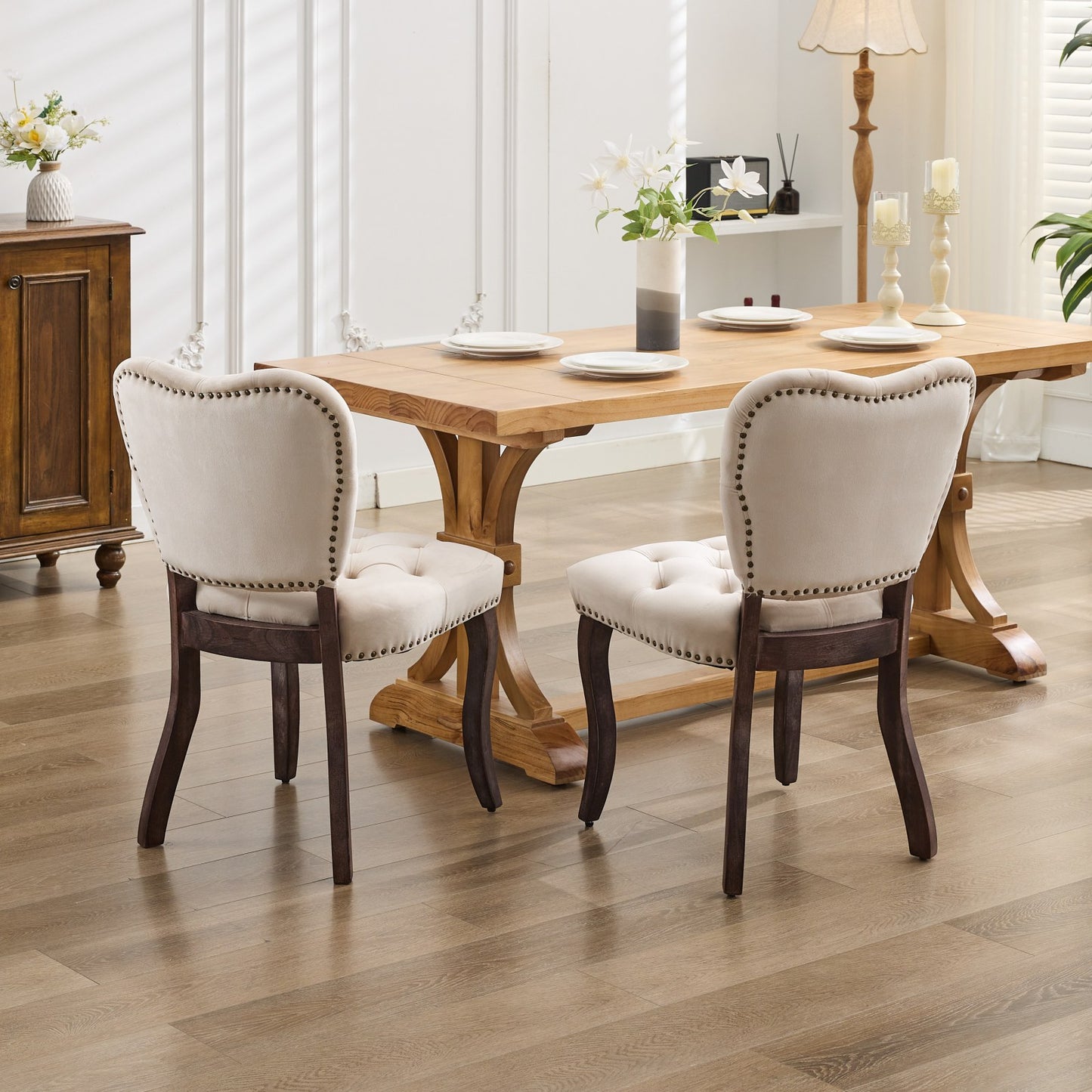 Tufted cream velvet dining chair with dark wood legs and brass nailhead trim