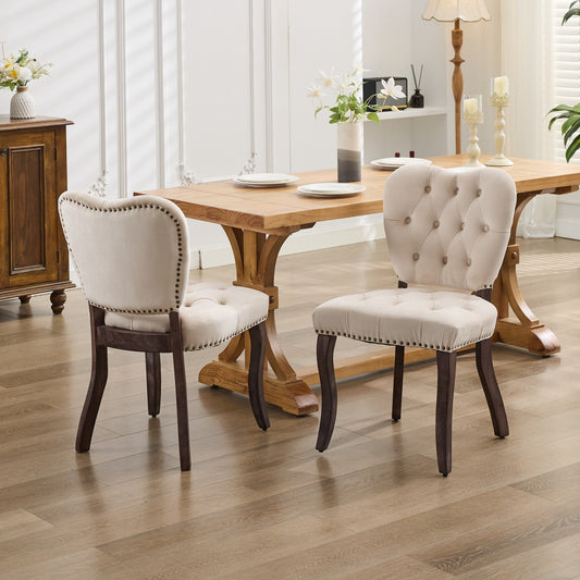 Cream tufted dining chair with nailhead trim and dark wood legs