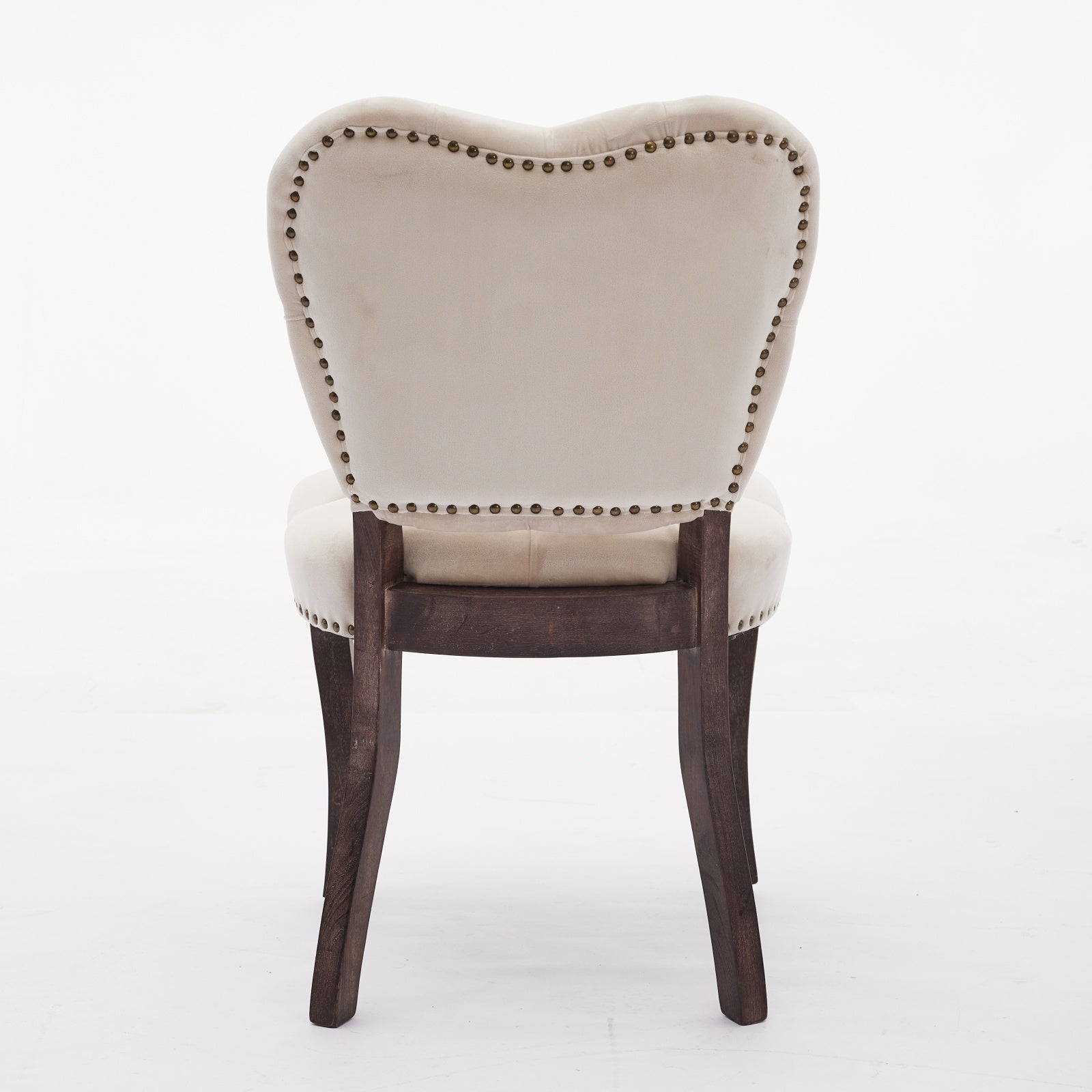 Cream velvet armchair with decorative brass nailhead trim and dark wood legs