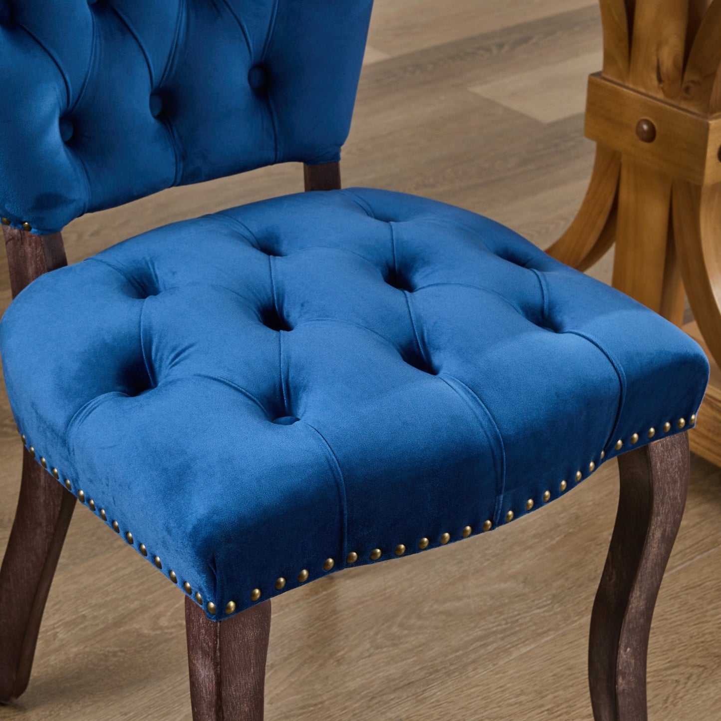 Deep blue velvet tufted accent chair with brass nailhead trim
