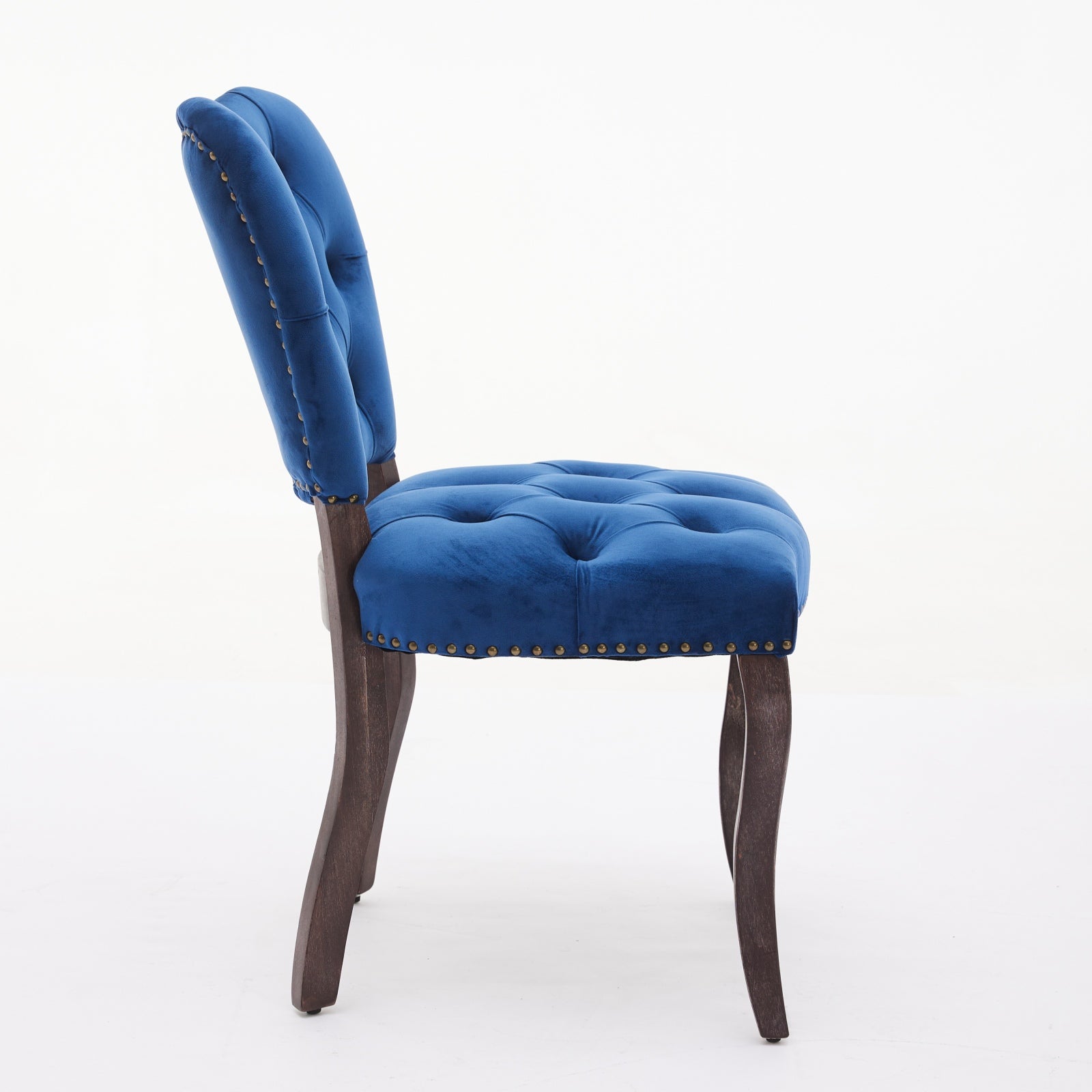 Blue velvet dining chair with button tufting and brass nailhead trim