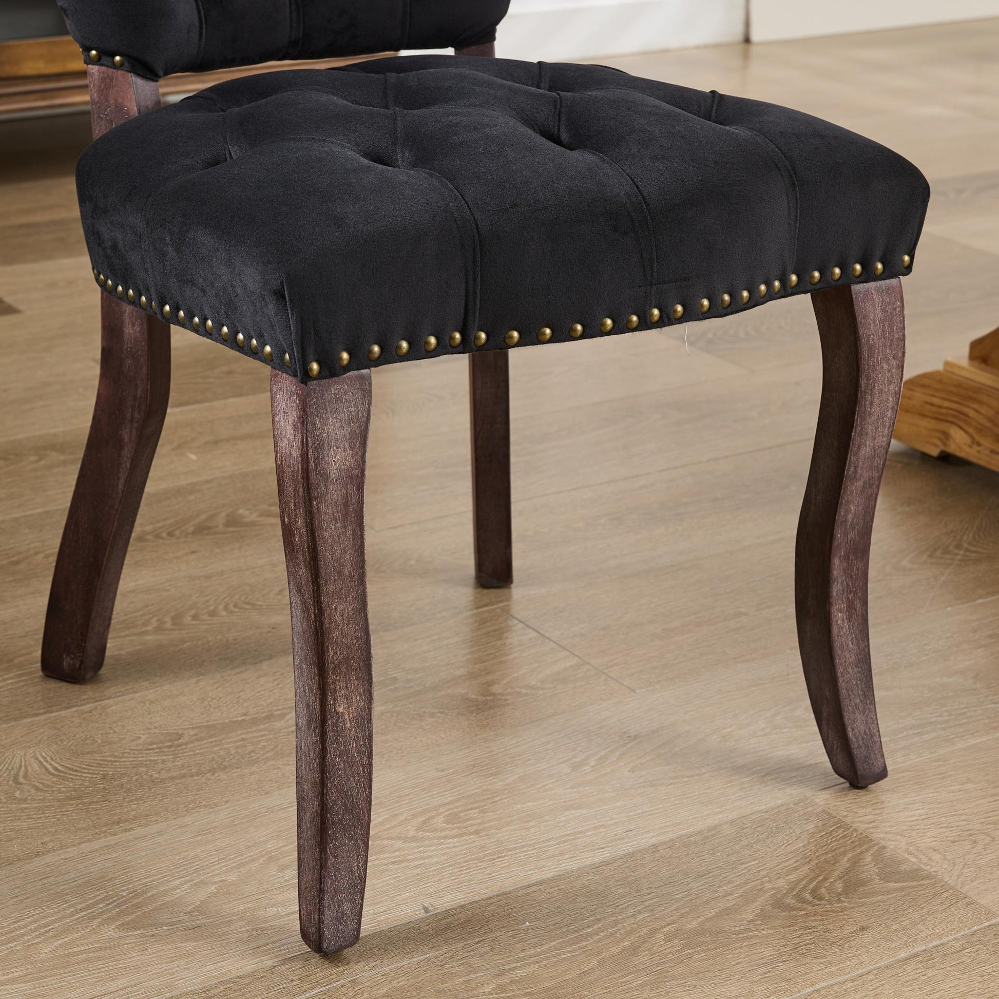 Black velvet dining chair with tufted seat and brass nailhead trim