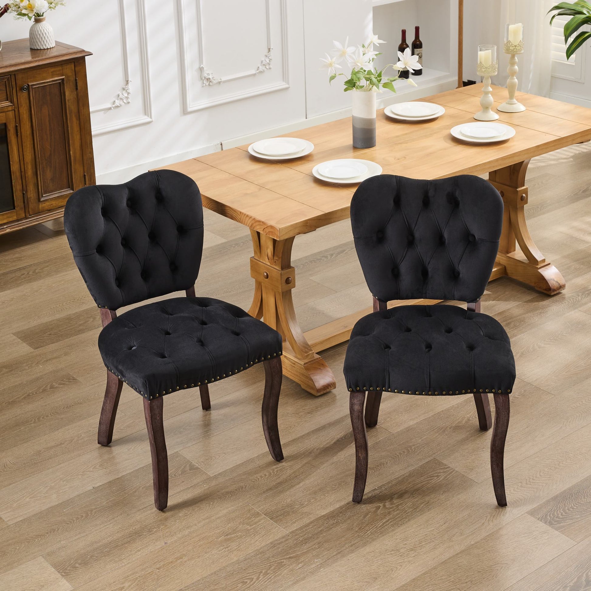 Black velvet tufted dining chair with brass nailhead trim