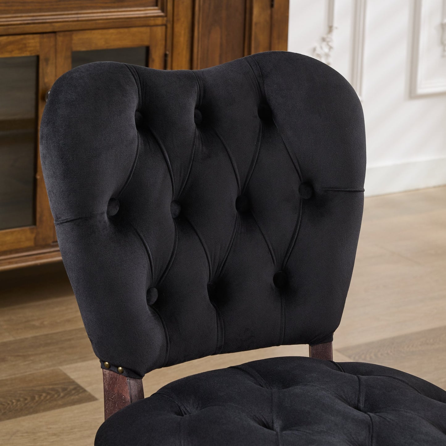 Black velvet tufted accent chair with dark wooden legs