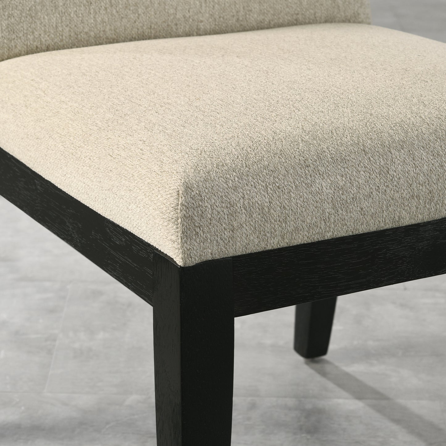Textured beige fabric seat on a modern black wooden dining chair