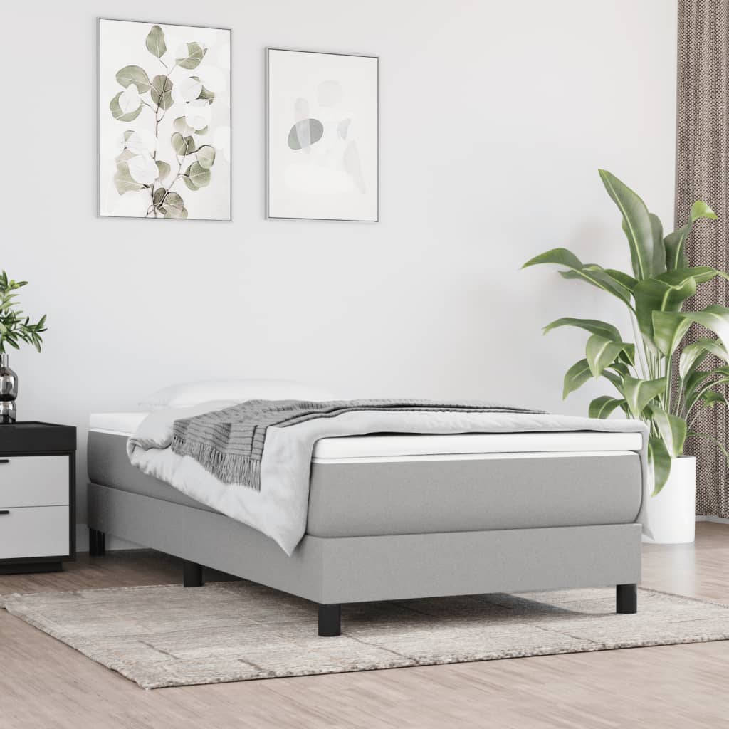 Grey upholstered single bed frame with mattress and topper