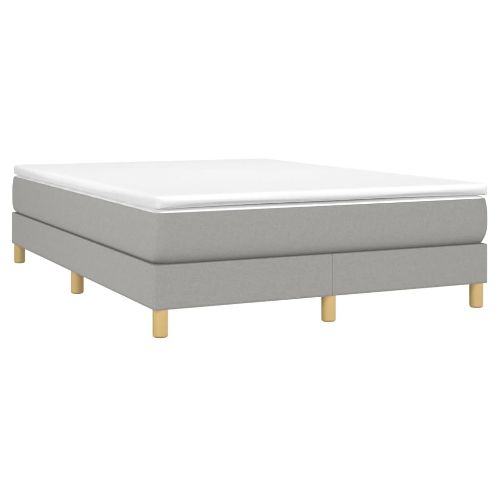 Grey upholstered bed base with white mattress and wooden legs