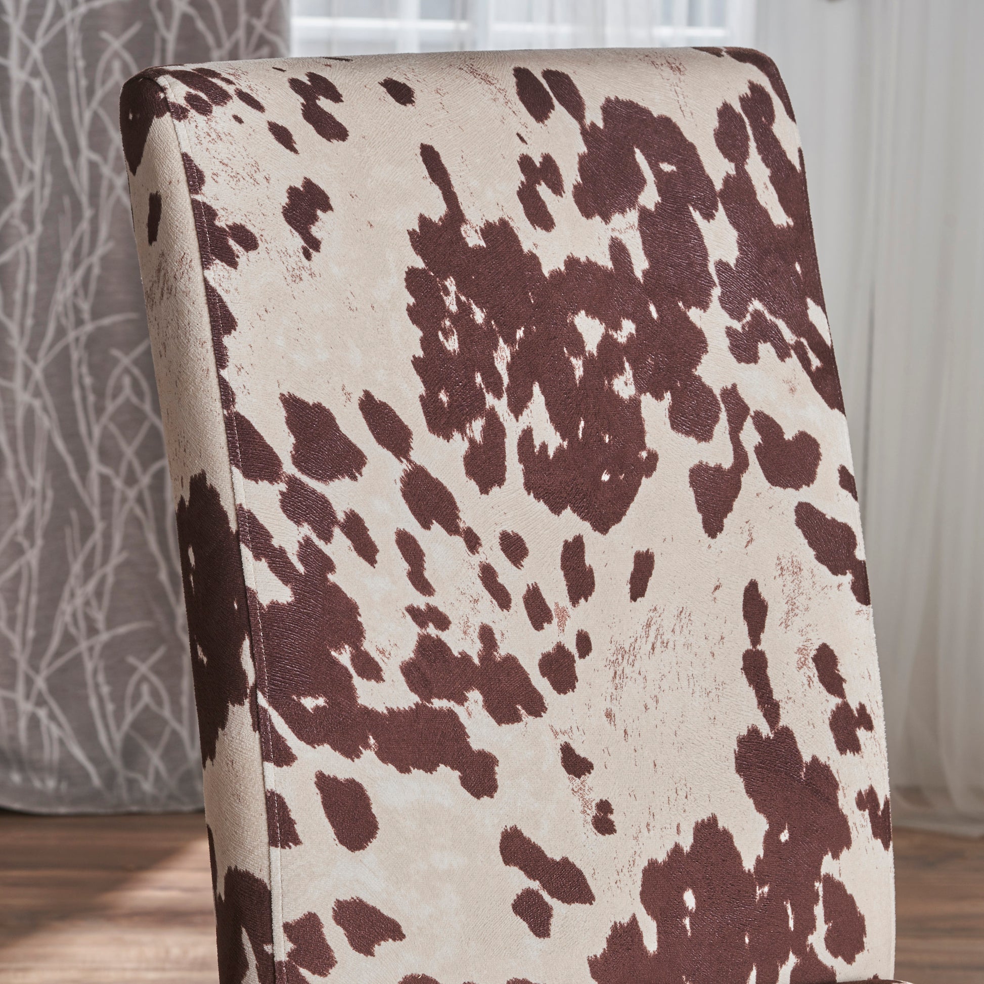 Closeup of a beige chair with a brown cowhide pattern