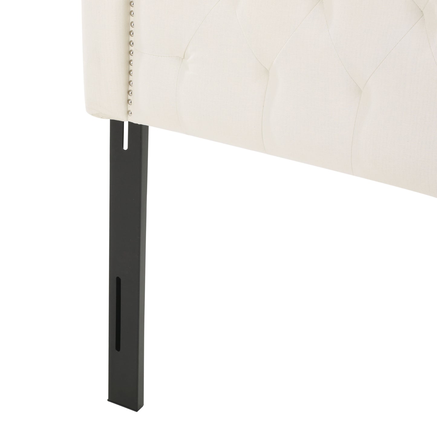 Cream upholstered headboard detail with silver nailhead trim and black metal leg