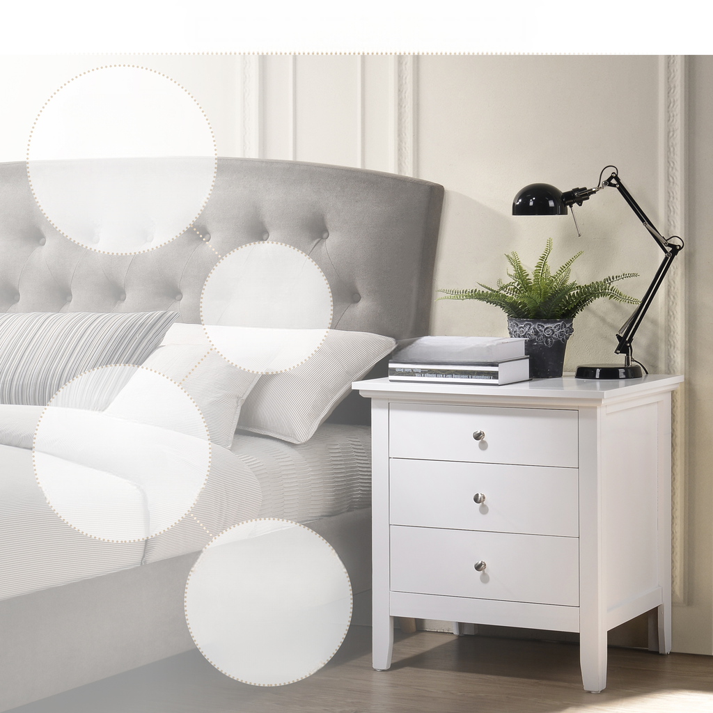 White threedrawer bedside table with silver knobs and a black desk lamp