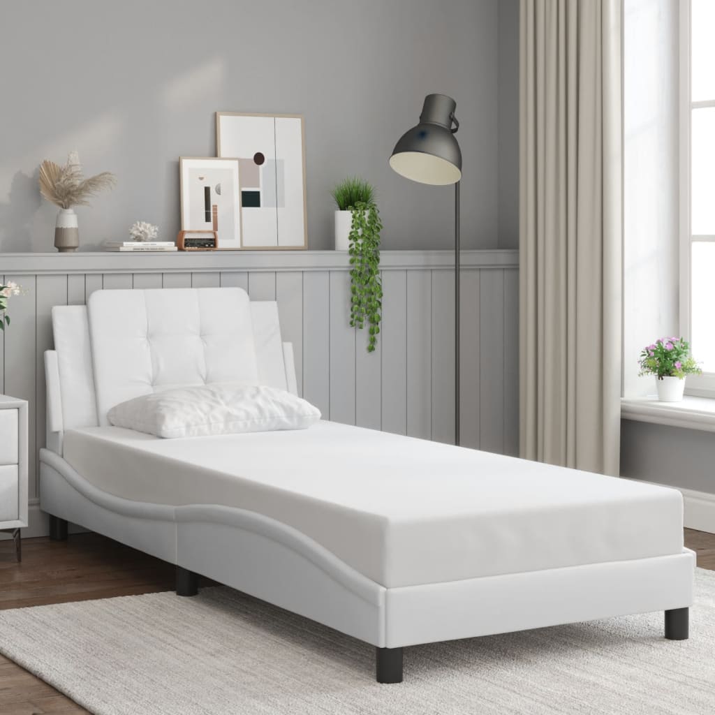 White faux leather chaise lounge with tufted headrest and accent pillow