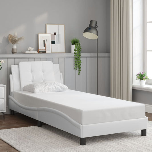 White faux leather chaise lounge with tufted headrest and accent pillow