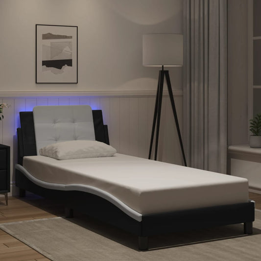 Modern black faux leather chaise lounge with white tufted headboard and builtin LED lights