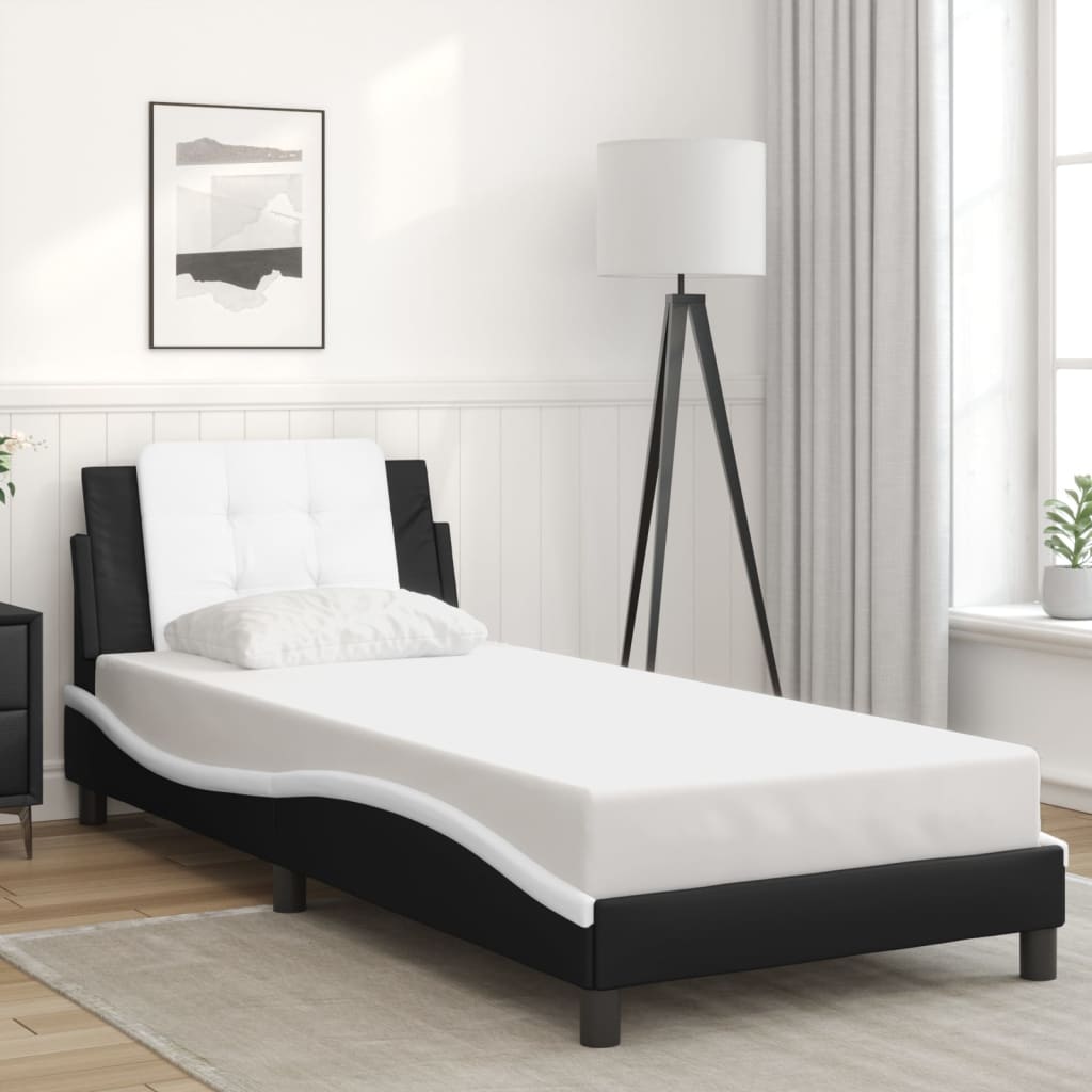 Black and white upholstered chaise lounge with button tufted headrest