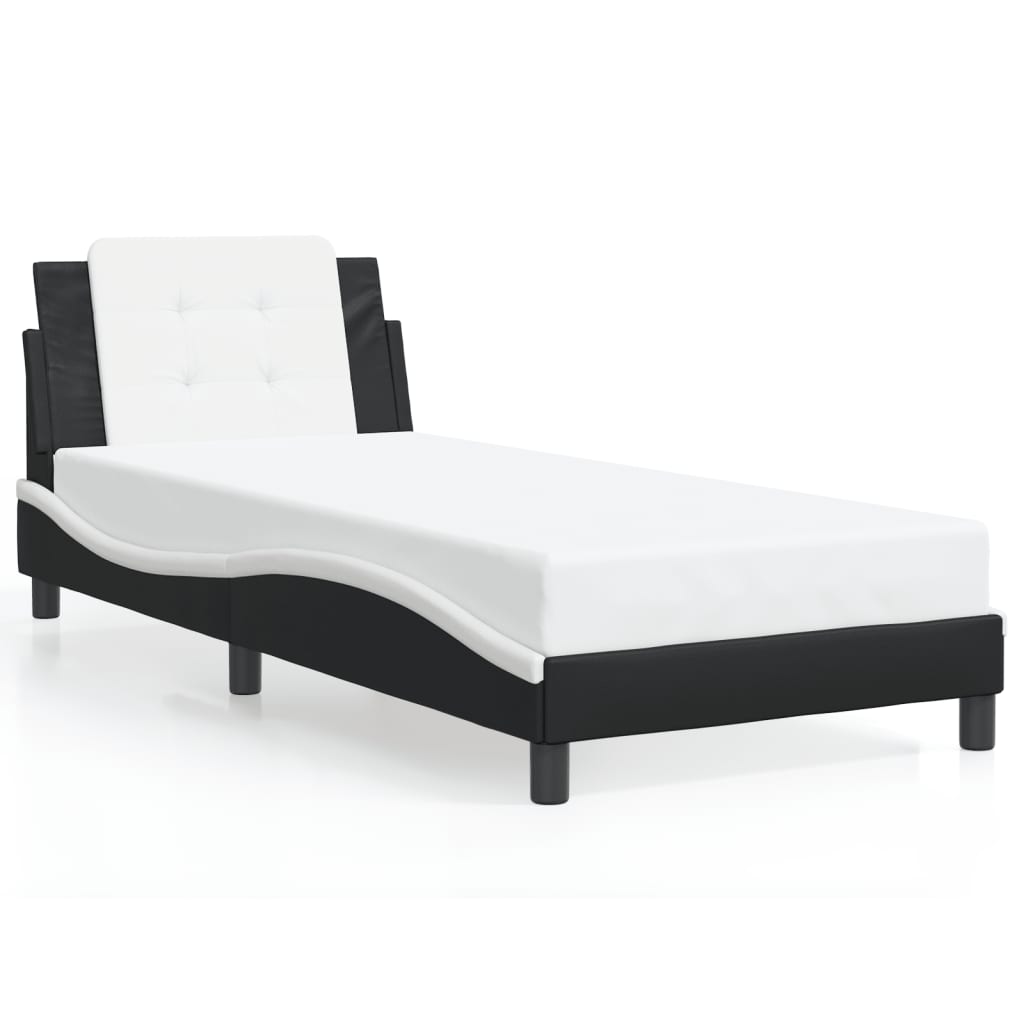 Black and white upholstered daybed with white mattress and pillow