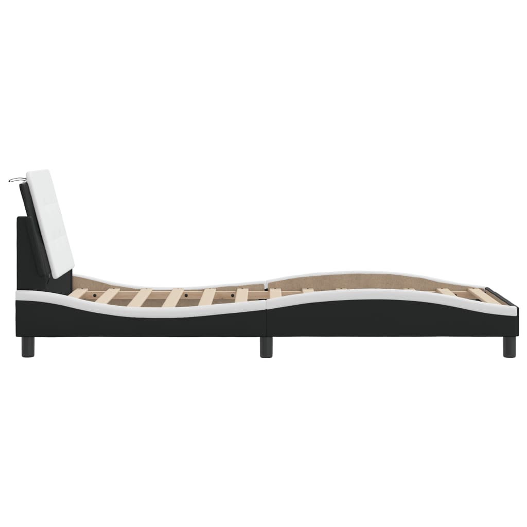 Black and white upholstered bed frame with tufted headboard and wooden slats