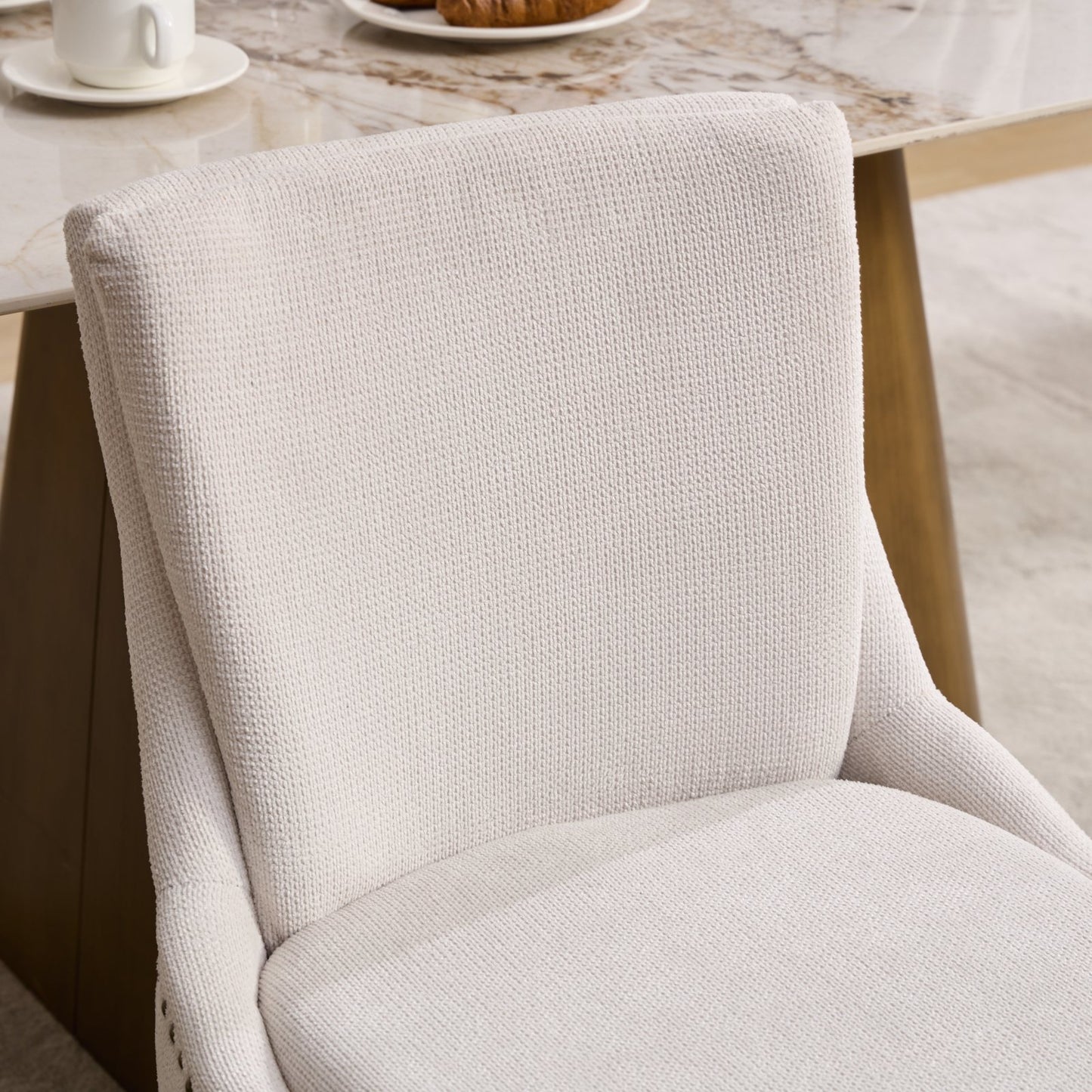 Cream upholstered dining chair with textured fabric and subtle piping detail