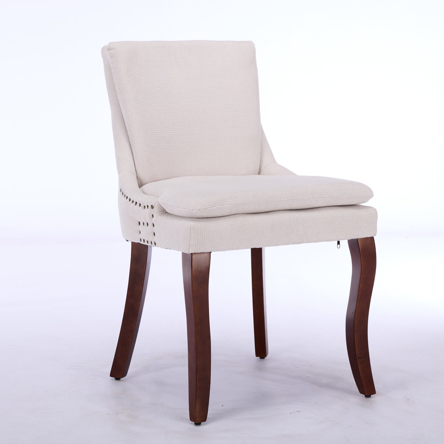 Cream upholstered accent chair with nailhead trim and dark wooden legs