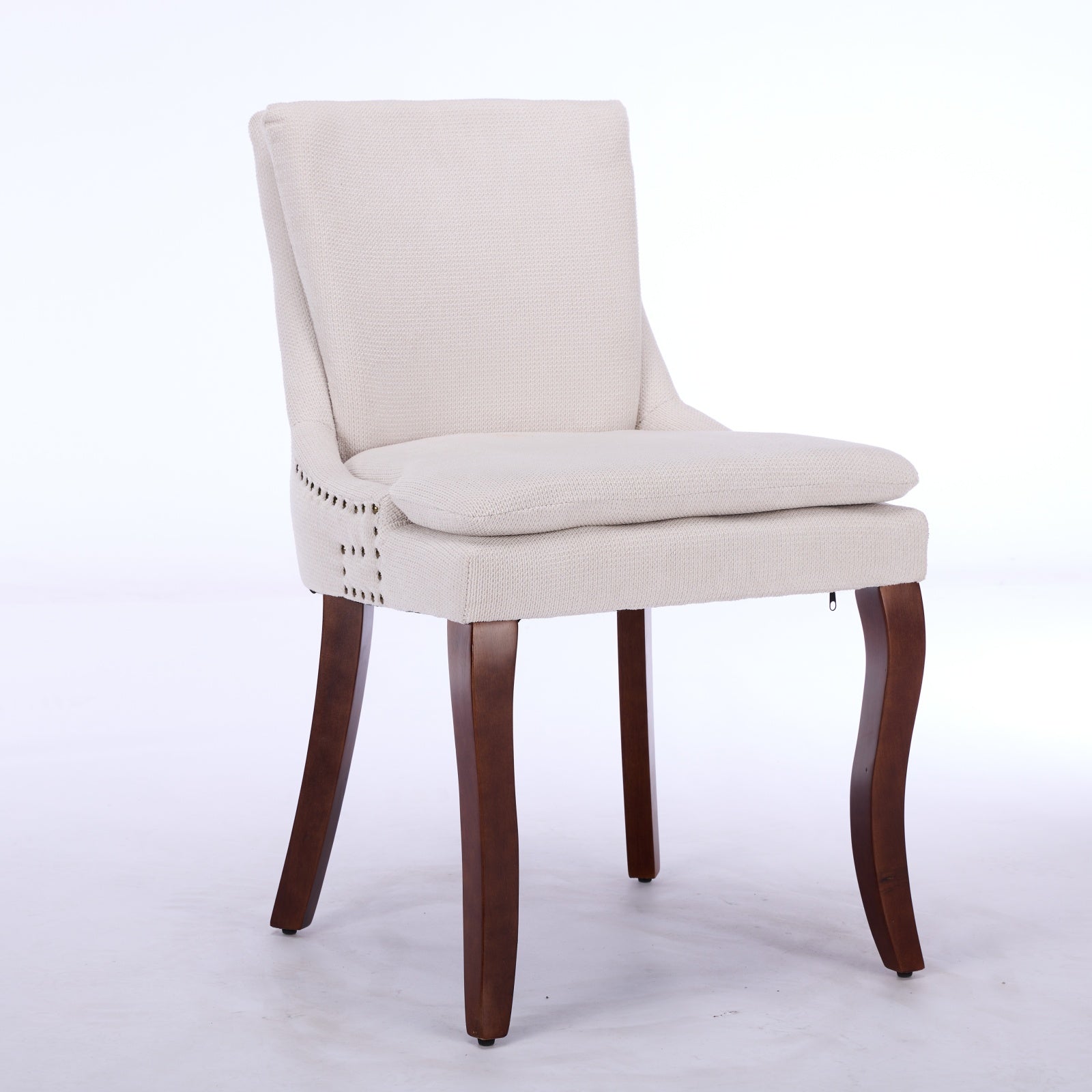 Cream upholstered accent chair with nailhead trim and dark wooden legs