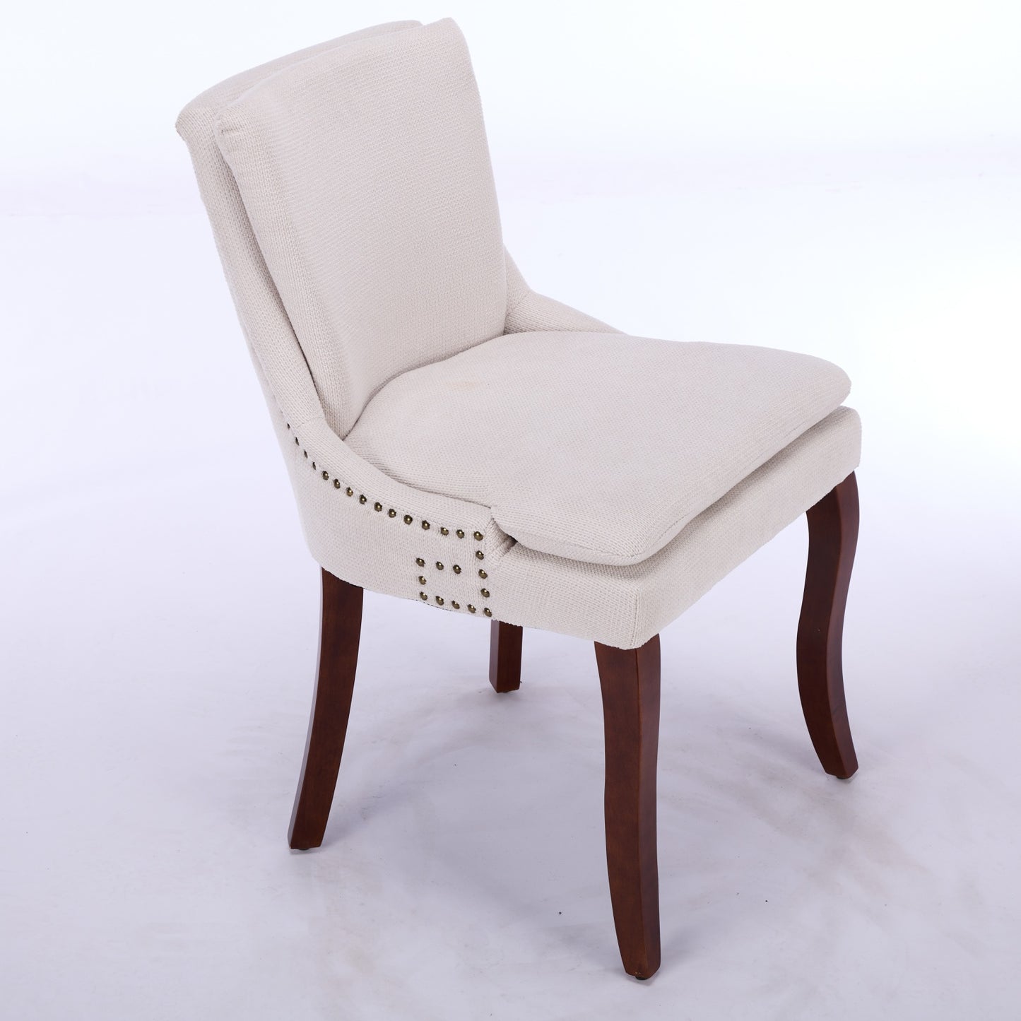 Cream fabric accent chair with brass nailhead trim and dark wood legs