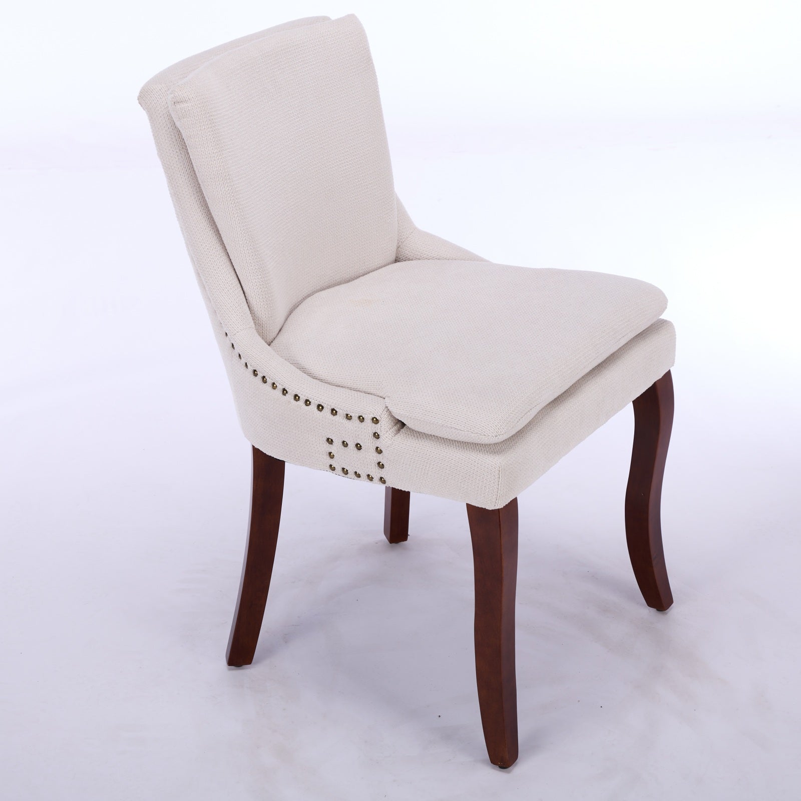 Cream fabric accent chair with brass nailhead trim and dark wood legs