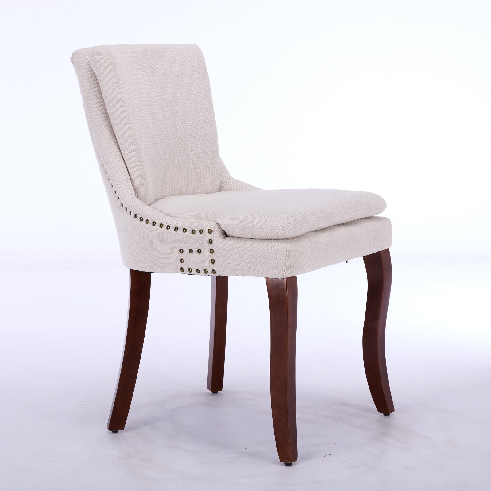 Cream upholstered dining chair with nailhead trim and dark wood legs