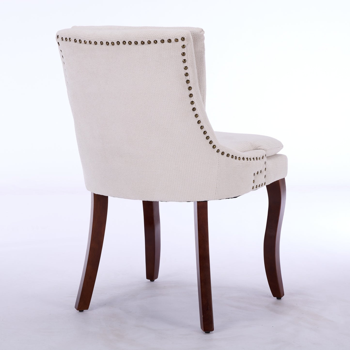 Upholstered dining chair with tufted nailhead trim and dark wood legs