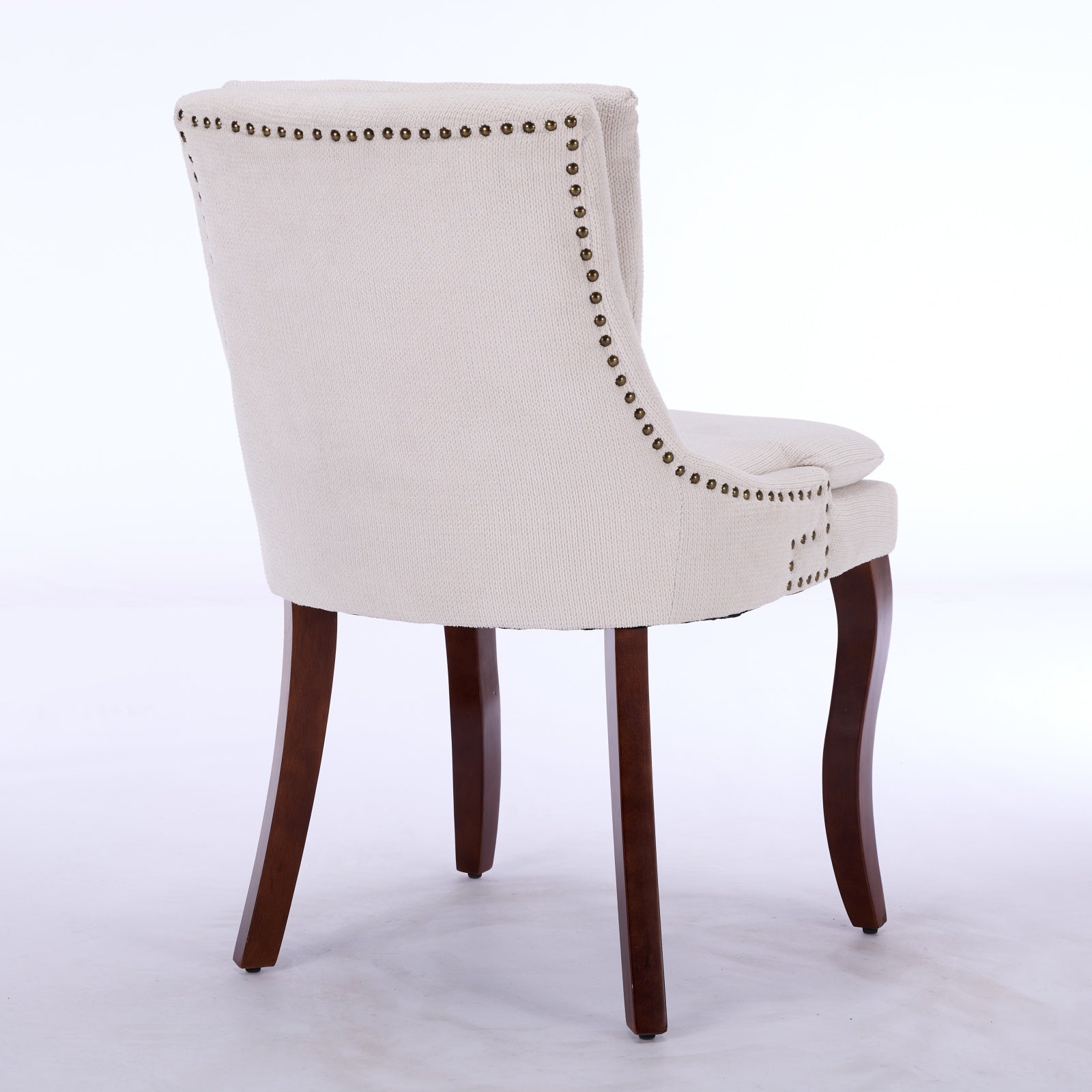 Upholstered dining chair with tufted nailhead trim and dark wood legs