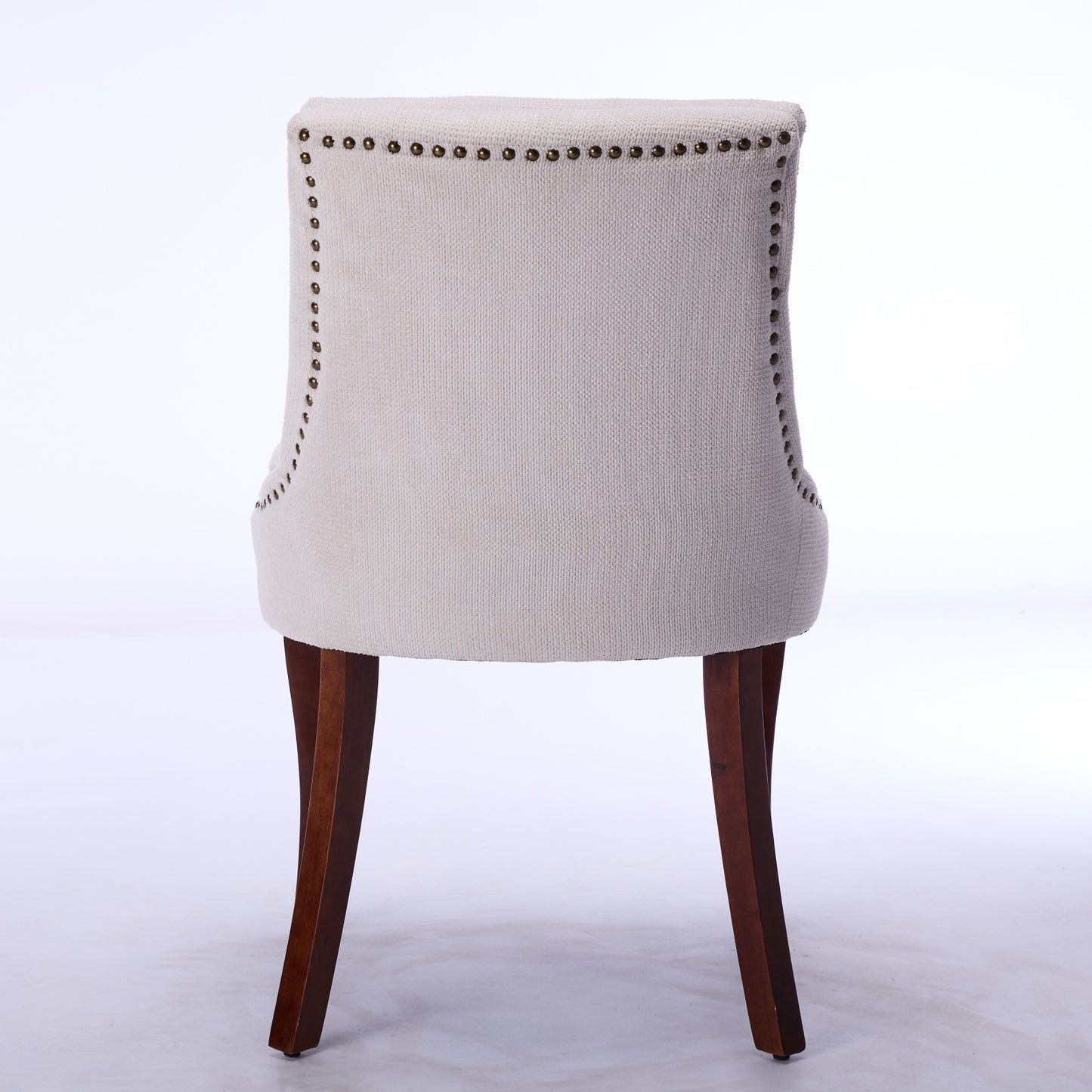 Tufted accent chair in beige linen upholstery with brass nailhead trim and dark wood legs