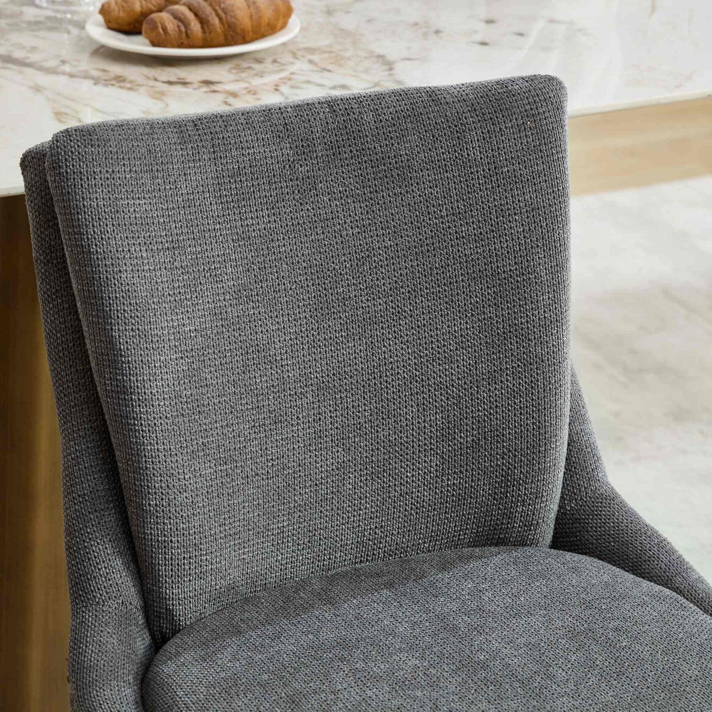 Closeup of a textured grey fabric dining chair back