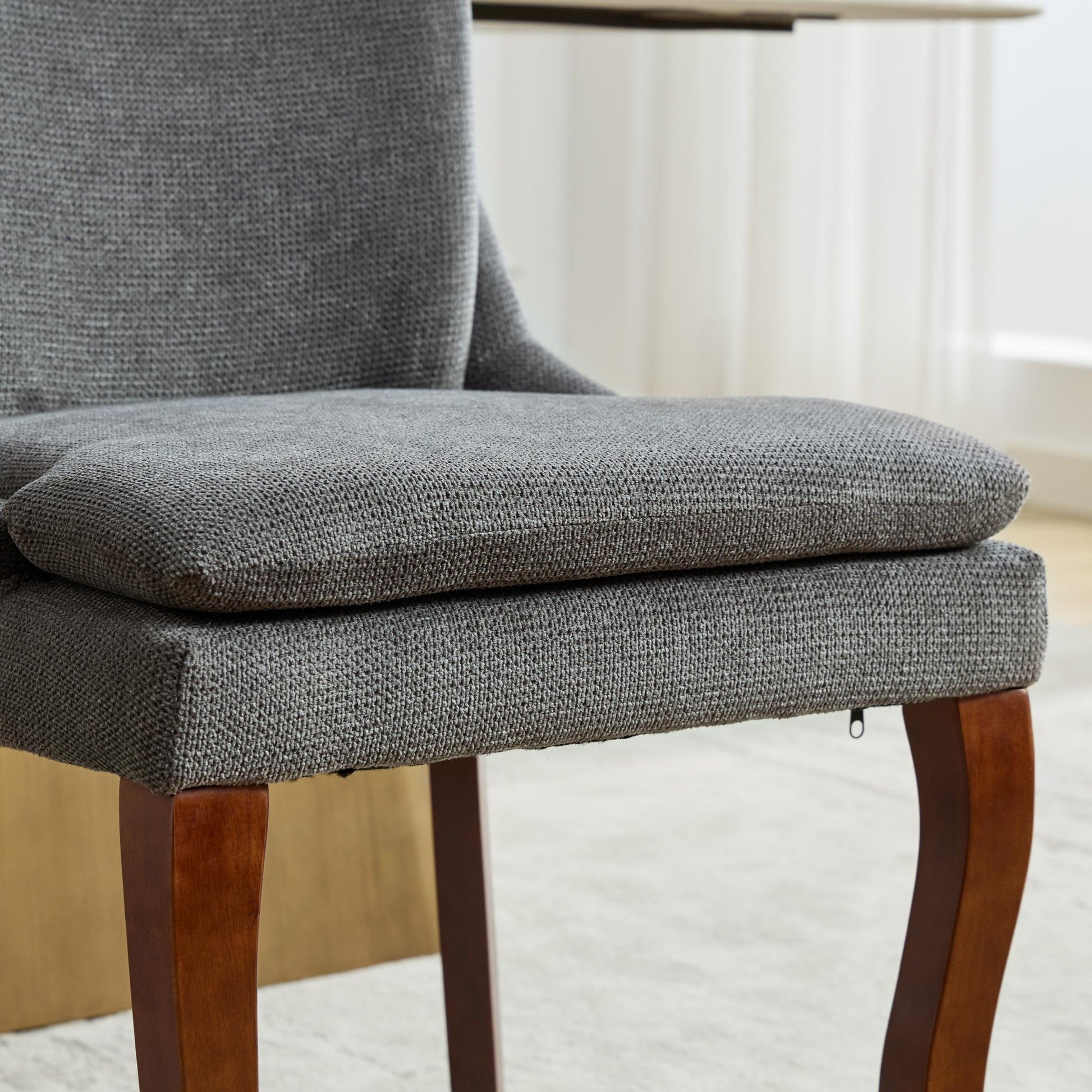 Plush grey upholstered dining chair with curved wooden legs