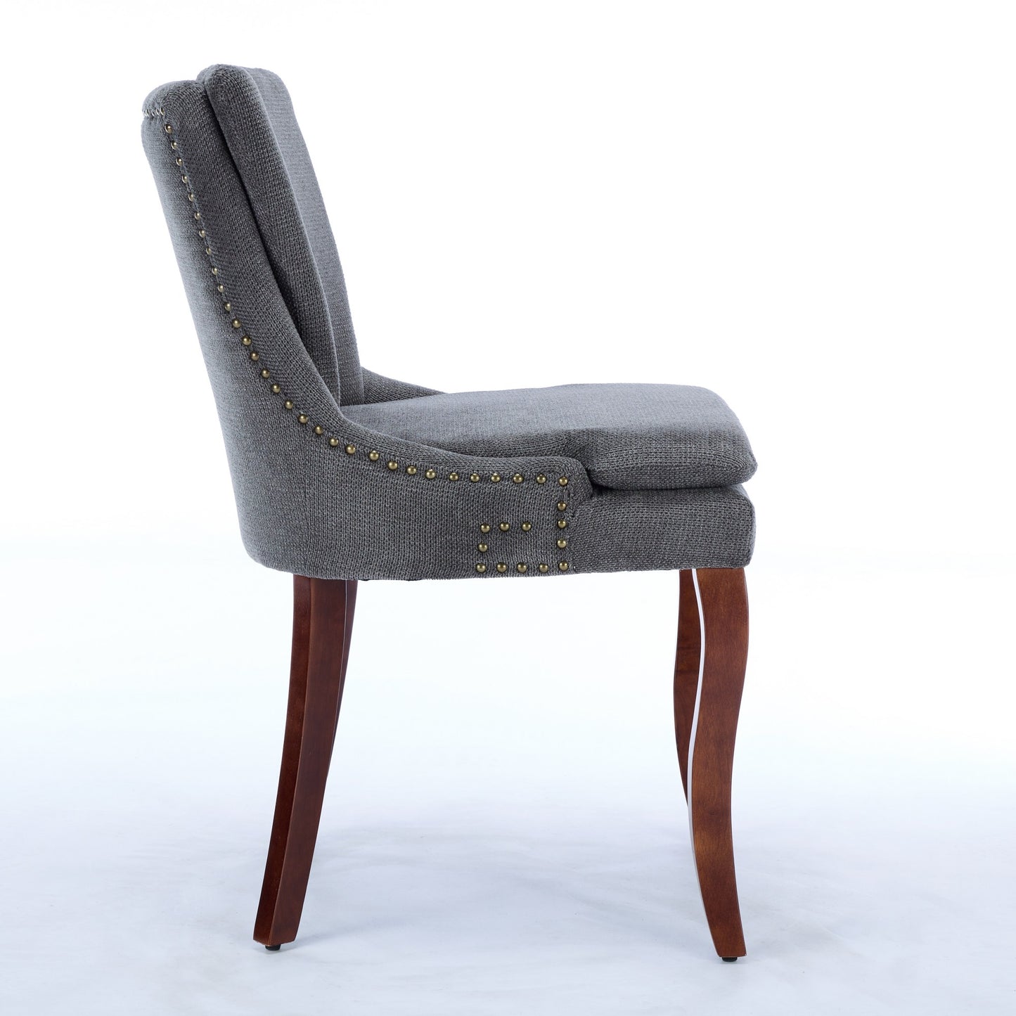 Gray upholstered dining chair with brass nailhead trim and carved wooden legs