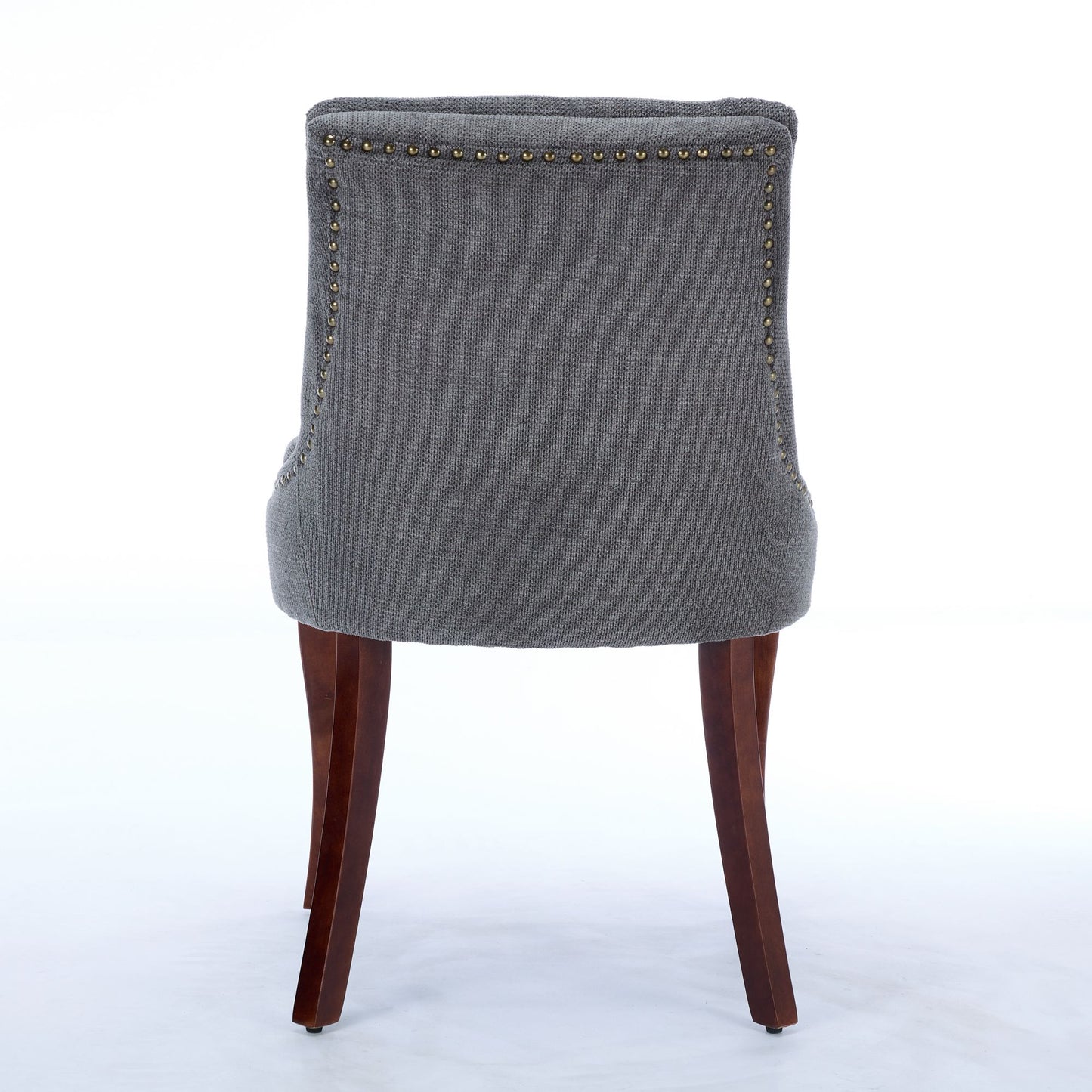 Dark grey tufted dining chair with brass nailhead trim and dark wood legs