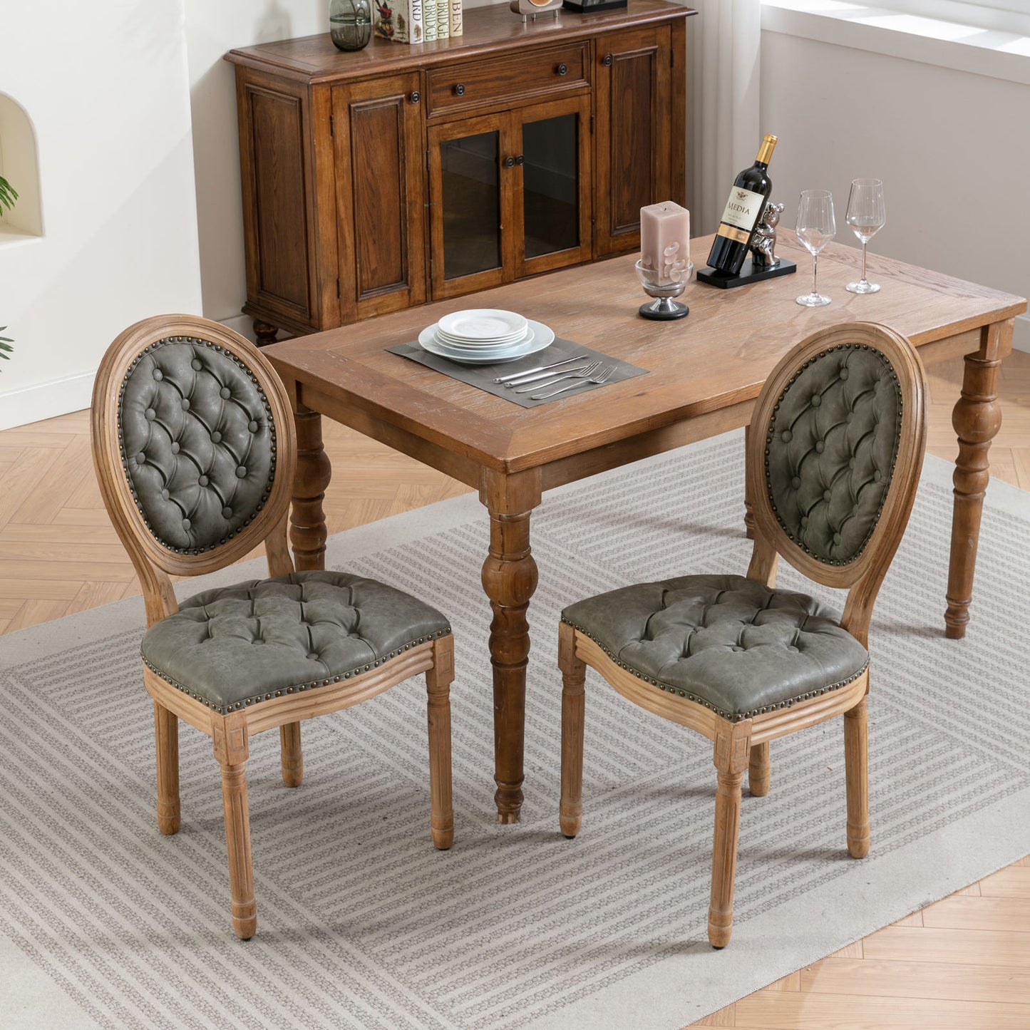 Grey tufted dining chairs with carved wood frames and nailhead trim