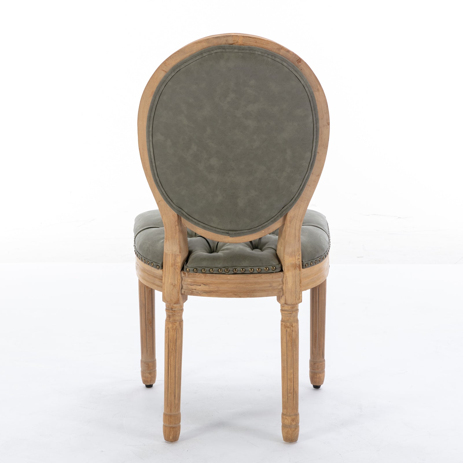 Tufted grey upholstered armchair with distressed wood frame and brass nailhead trim