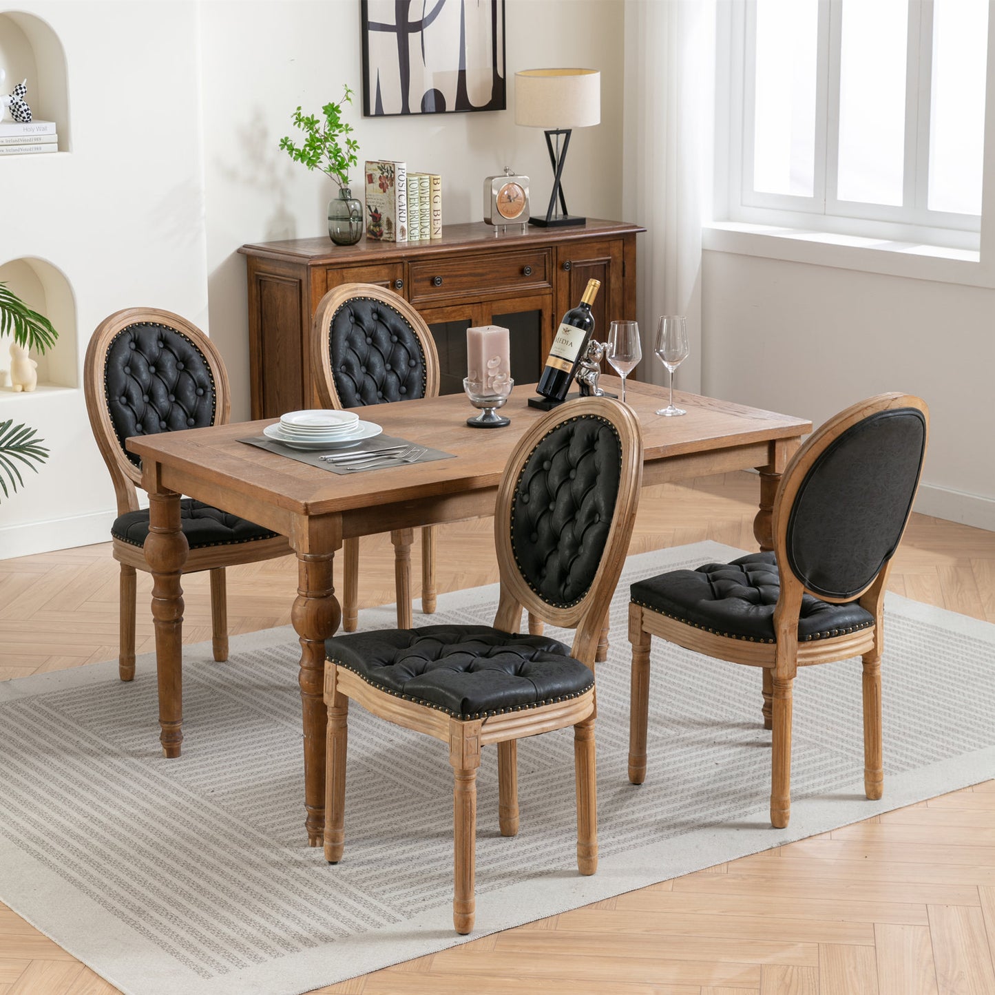 Four tufted black upholstered dining chairs with carved wood frames around a rustic wood table