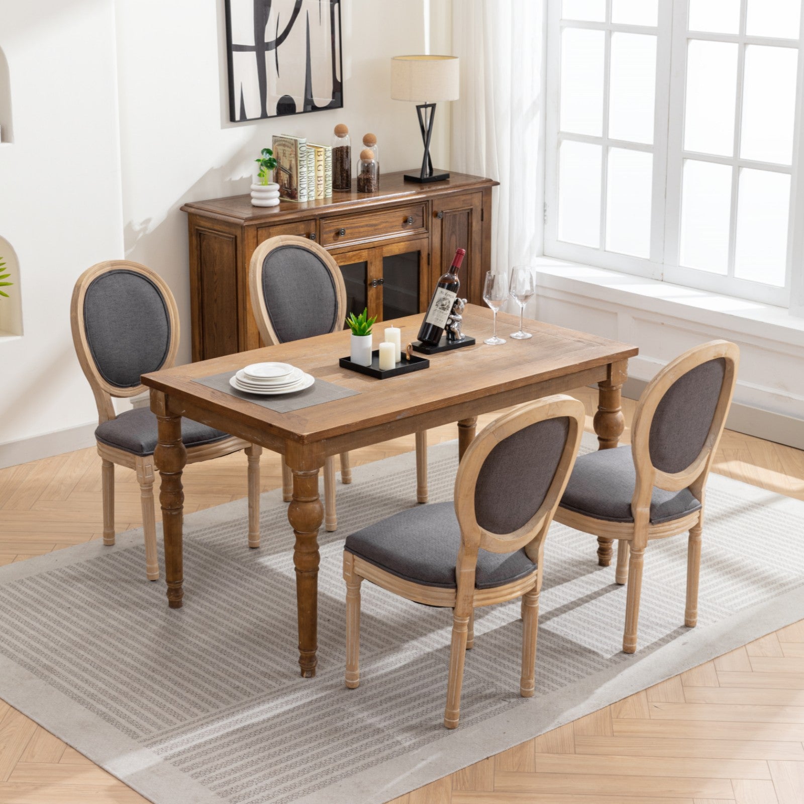 Rustic oak dining table with four grey upholstered chairs